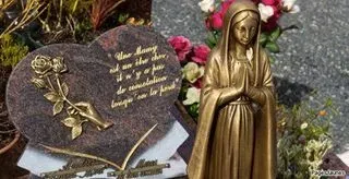 Statuette de la Vierge Marie en prière aux côtés d'une plaque funéraire en forme de cœur