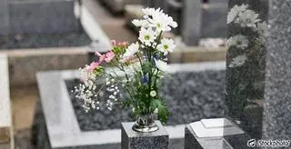 Bouquet de fleurs fraîches posé sur un monument funéraire en granit