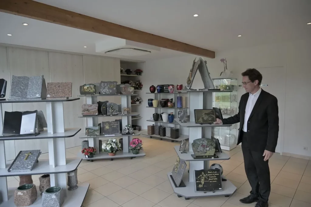 Conseiller funéraire présentant une exposition de plaques commémoratives en magasin
