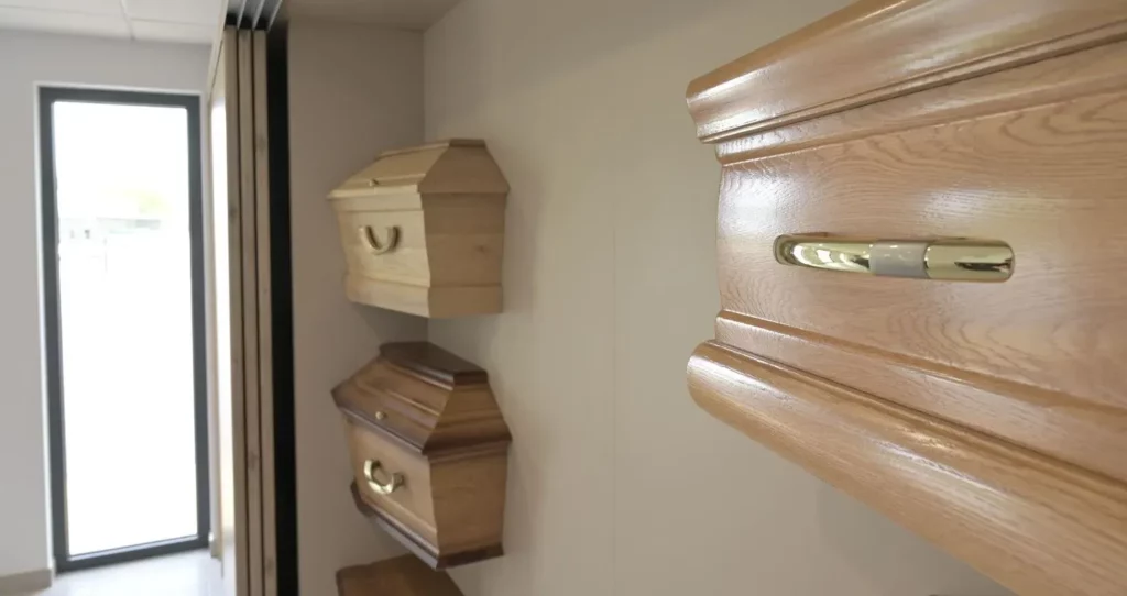 Modèles de cercueils en bois exposés dans une salle de présentation